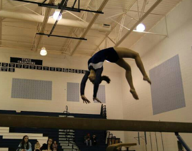 Cobb performs a backhand spring on the balance beam.