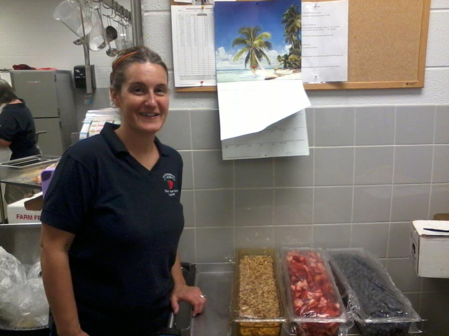 Cafeteria Manager Tricia Newcomb with the various toppings available at the yogurt bar.