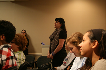 Speaker Melissa Crowder Rhoder and students watch a video of a child with Dravet Syndrome and how medical marijuana helps her.