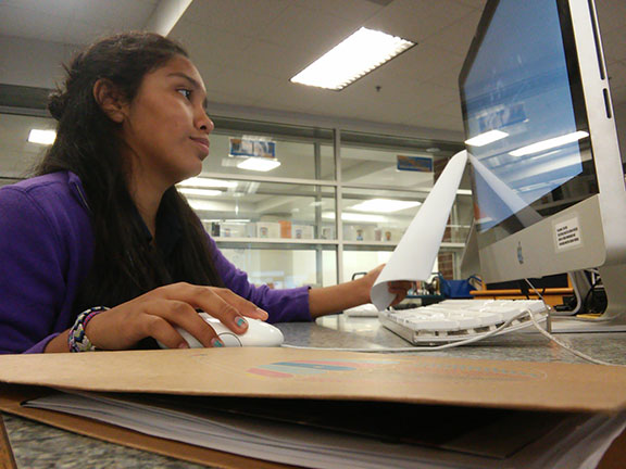Lizet Muniz is working on a lab report in the library. 