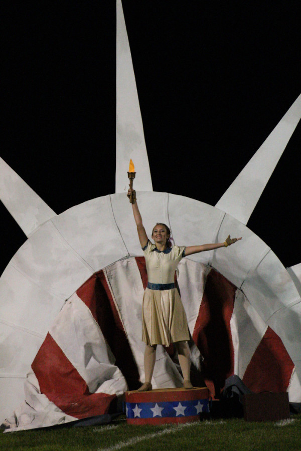 Junior Megan Lebarge holds a torch during the half time show.