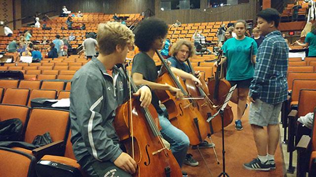 Thomas Dale High School juniors Palmer Jones, Nathaniel Davis, and Matthew Driver practice their scales together while chatting about the audition.