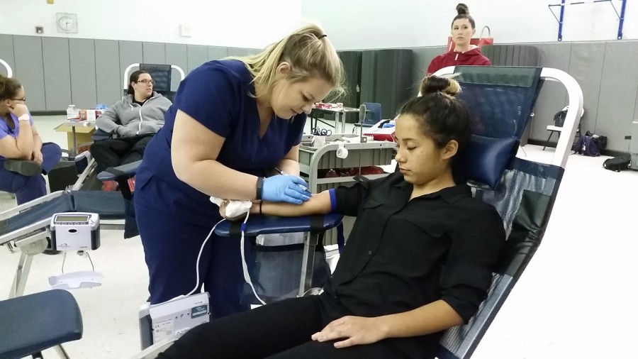 Junior Abrianna Castro gets prepared by a nurse to give blood at the annual fall blood drive.