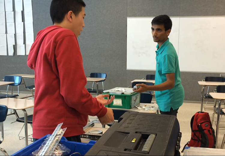 Lee (left) and Ahmed (right) work for the robotics team after school.