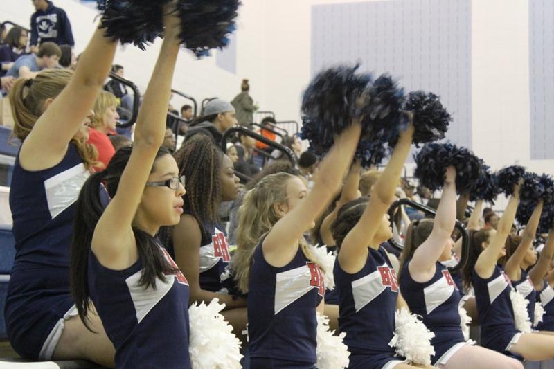 The sideline cheer team cheers on the JV basketball players during the home game against James Wood high school.