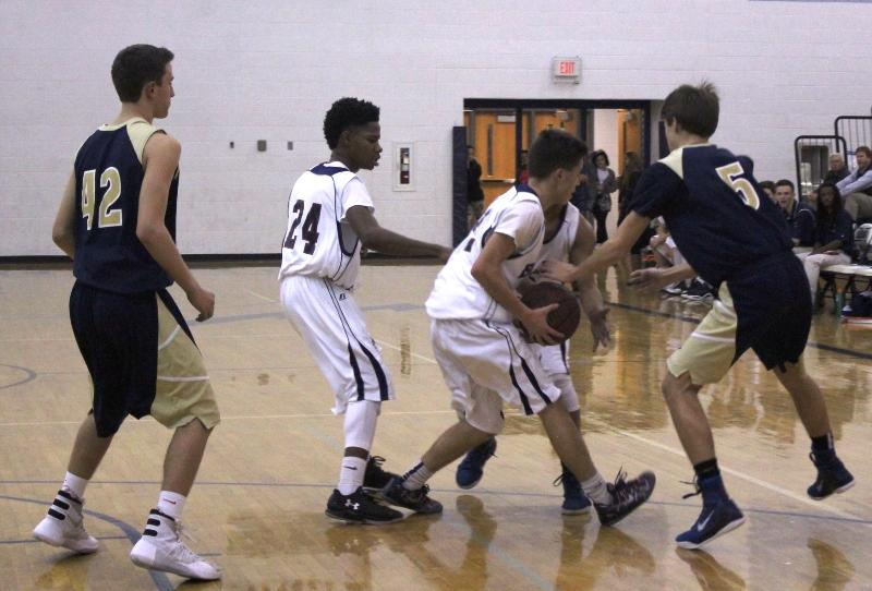 JV basketball players freshman Kobe Johnson and junior Hakeem Sharief steal the ball from their opponents hands during the home game against James Wood high school.