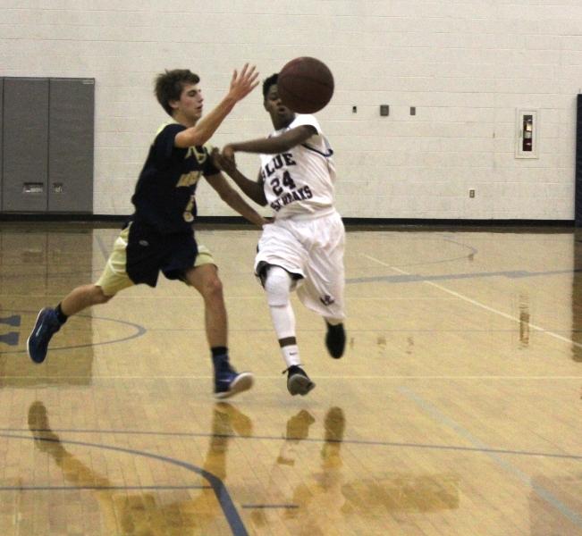JV basketball player Hakeem Sharief passes the basketball to a teammate during the home game against James Wood high school.