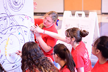 Students add tiles to the mural