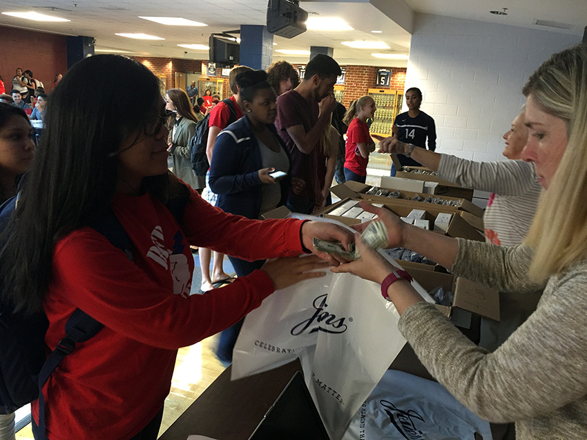 Senior Marjorie Bonga pays for her cap and gown during her lunch on Friday. 