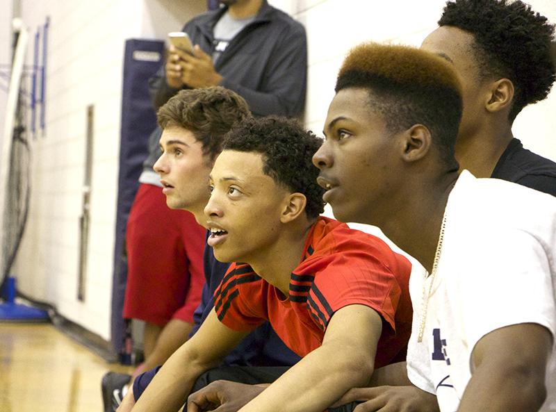 Member of the junior HHS volleyball team watch intently on the bench as the TA Knights keep the point alive.