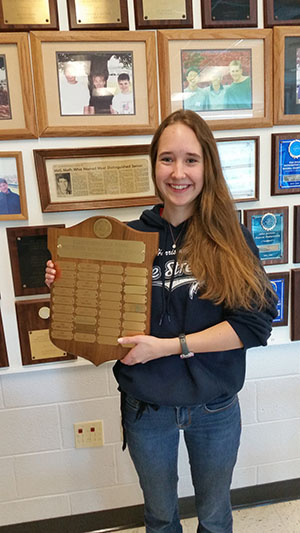Kayla holds the plaque for the Bill Turner Award with her name freshly engraved on it.