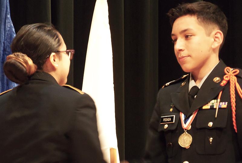 Freshman Fernando Posada receives one of his six awards from Isis Gutierrez.
