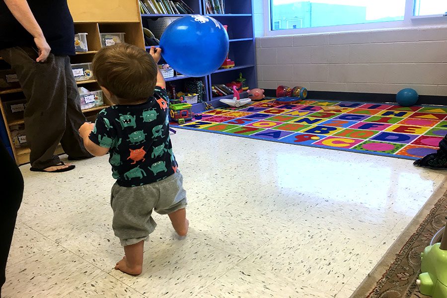 Out off all of the nursery toys, this toddler chooses to play with his balloon.