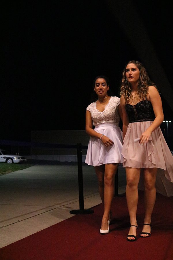 Juniors Constance Komara and Katerin Hernandez walk the red carpet into homecoming.
