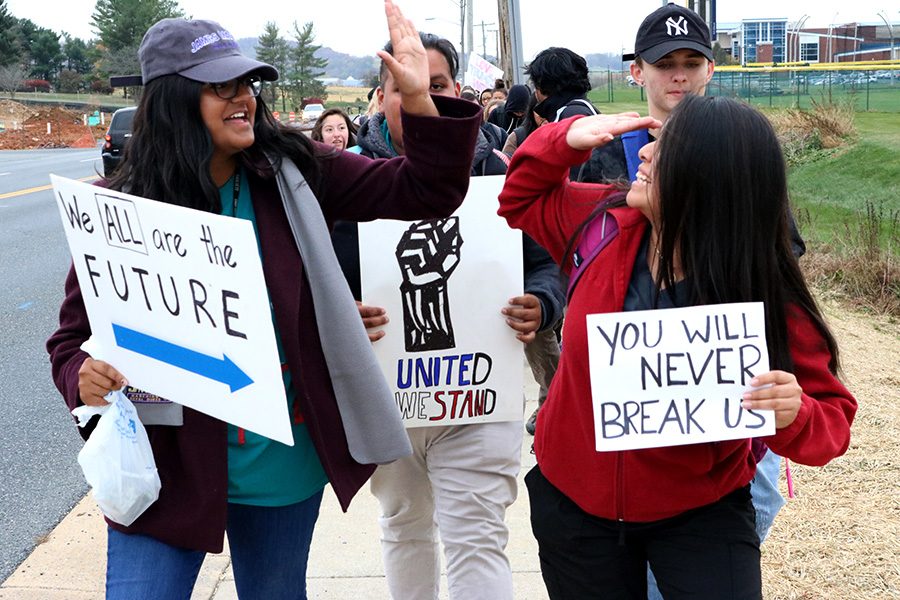 Juniors Dharakshan Shaikh (left) and Ana Santiago (right) high-five during the walkout