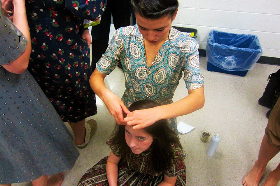 Julia Inouye helps do Gabby Wilsons hair pre-performance.