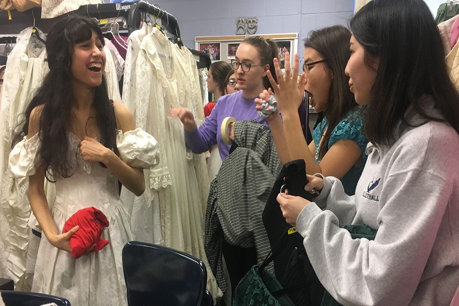 A group of students from the cast prepares their costumes before going out to practice