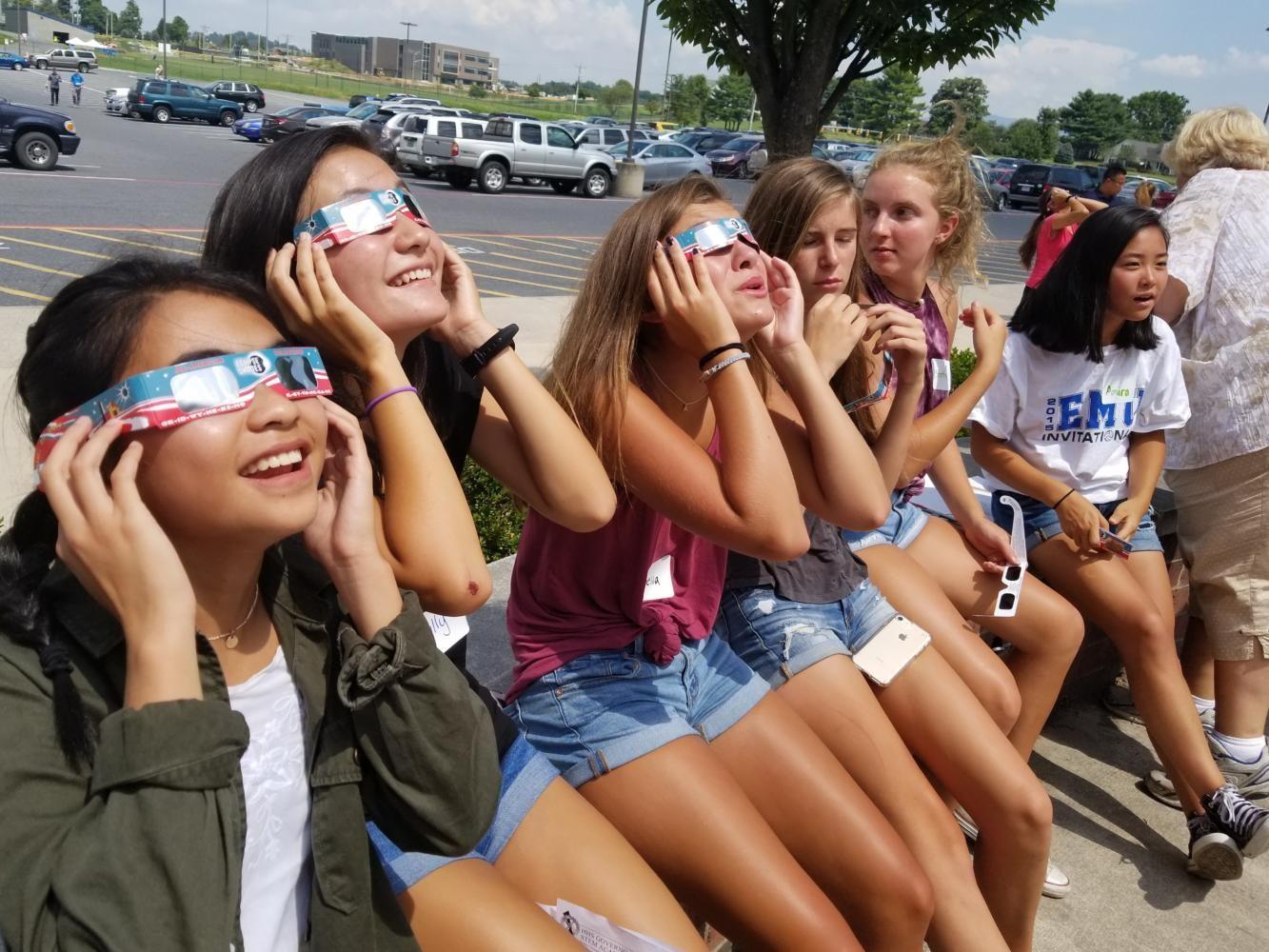 Freshman Mariel Joven and her group watch through glasses as the eclipse begins.