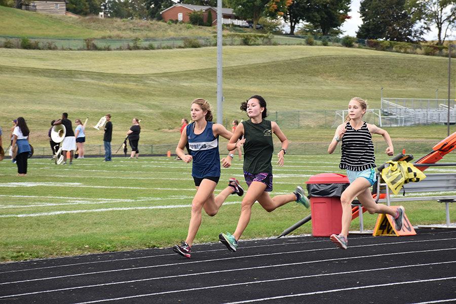 (From left to right) Junior Abby Campillo, freshman Holly Bill and sophomore Sarah Deloney run strides during a cross country practice.