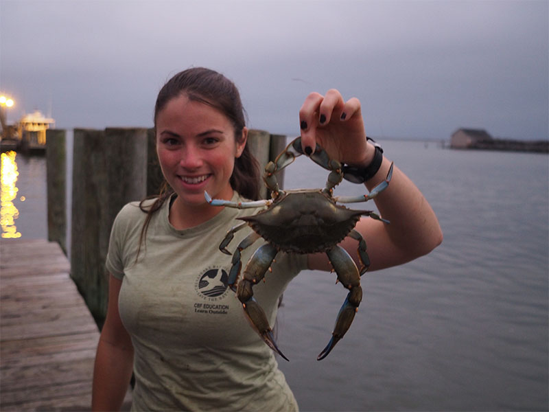 HHS STEM student holds up the biggest crab ever seen on Smith Island.
