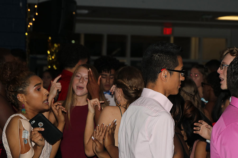 A group of girls dance together at homecoming.