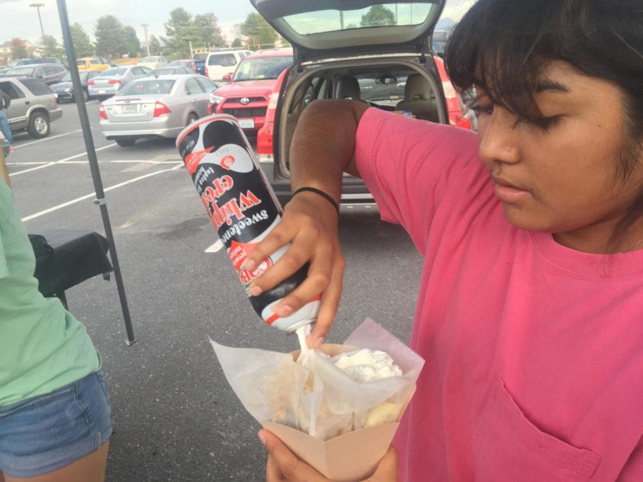 Senior Eva Didot piles whip cream onto a Banana crepe. 