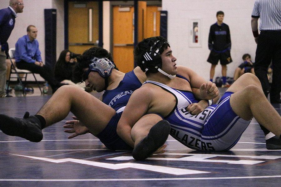 Fahad Mohammed and a Spotswood wrestler struggle on the mat during the end of the second period of their match.