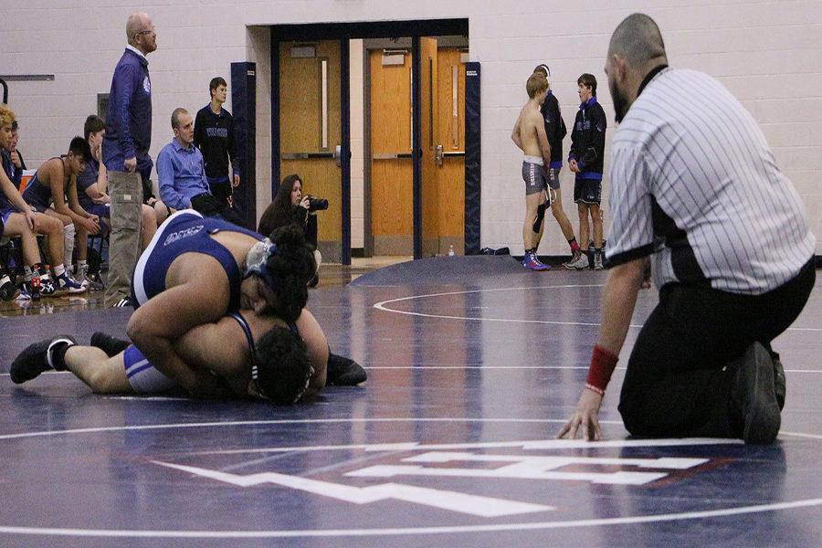 Fahad Mohammed pins down the Spotswood wrestler while the referee watches to award points. 