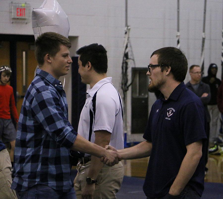 Joel Clevenger shakes hands with head coach Billy Bower during the senior night presentation.