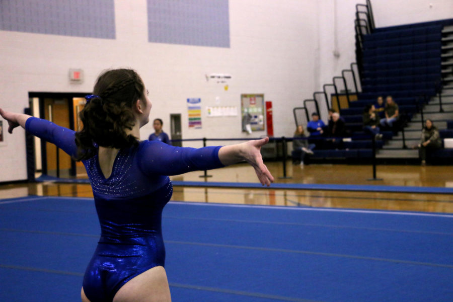 Freshman Chloe Nichols smiles at the crowd in the end of her routine on floor.