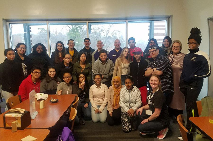 Ninth and eighth grade On the Road students taking a picture with JMU president, Jonathan R. Alger, after eating lunch with him on a trip.