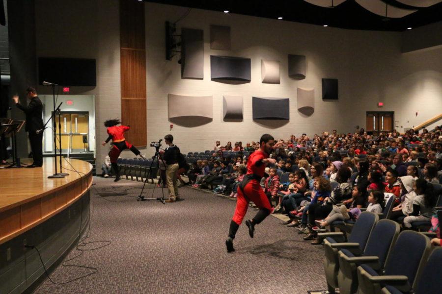 Andrew Eli and Jack Fleming run around the auditorium dressed as characters from The Incredibles.