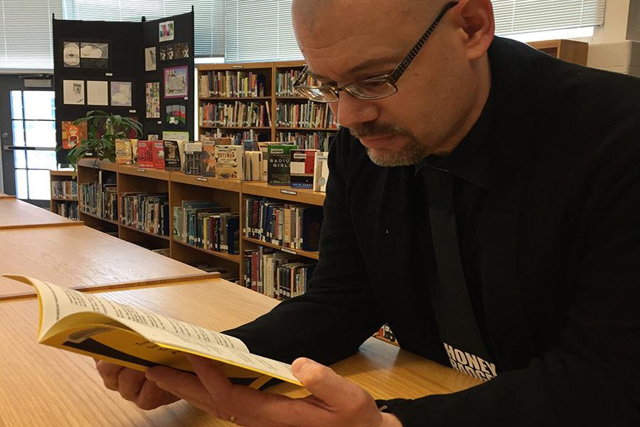 Librarian Bradley Walton reads a book in the library.