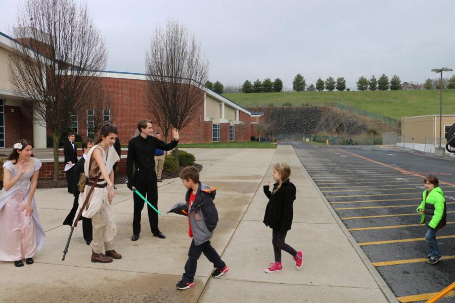 Students dressed as Star Wars characters greet the kids.