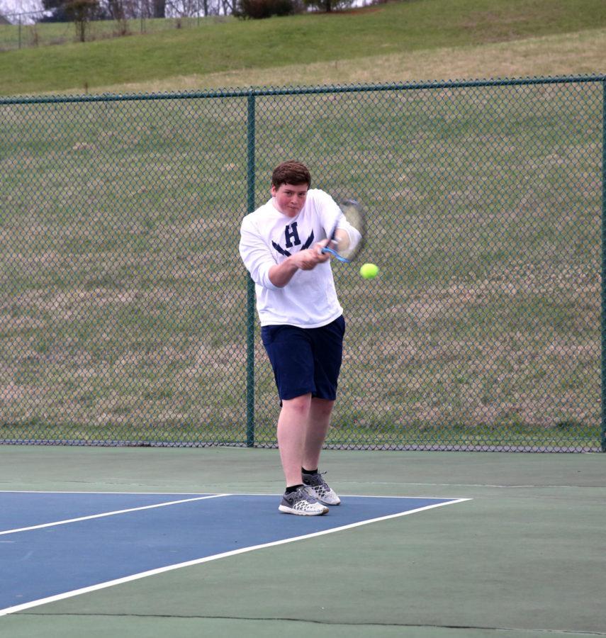 Junior Tobias Yoder steps up and returns a low shot from Turner Ashbys Canon Secord during his doubles match.