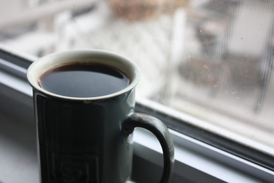 A cup of coffee sits in a windowsill 