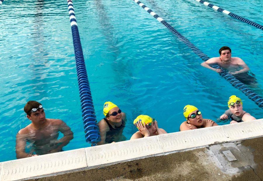 Junior Kyle Brown, freshman Eva Velker, sophomore Carly Corso (left to right) and junior Nathan McIntire (back) pay attention to head coach Chad Gusler as he explains the workout. 