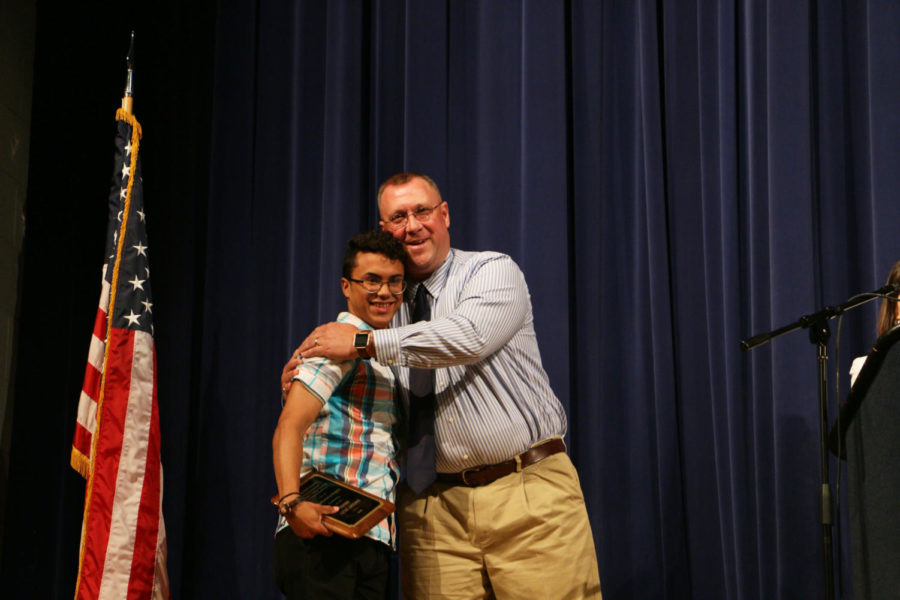 Senior Guillermo Torres and athletic director Darrell Wilson have a congratulatory moment on stage after Torres receives an Athletic Scholarship in honor of his success in wrestling at HHS. 