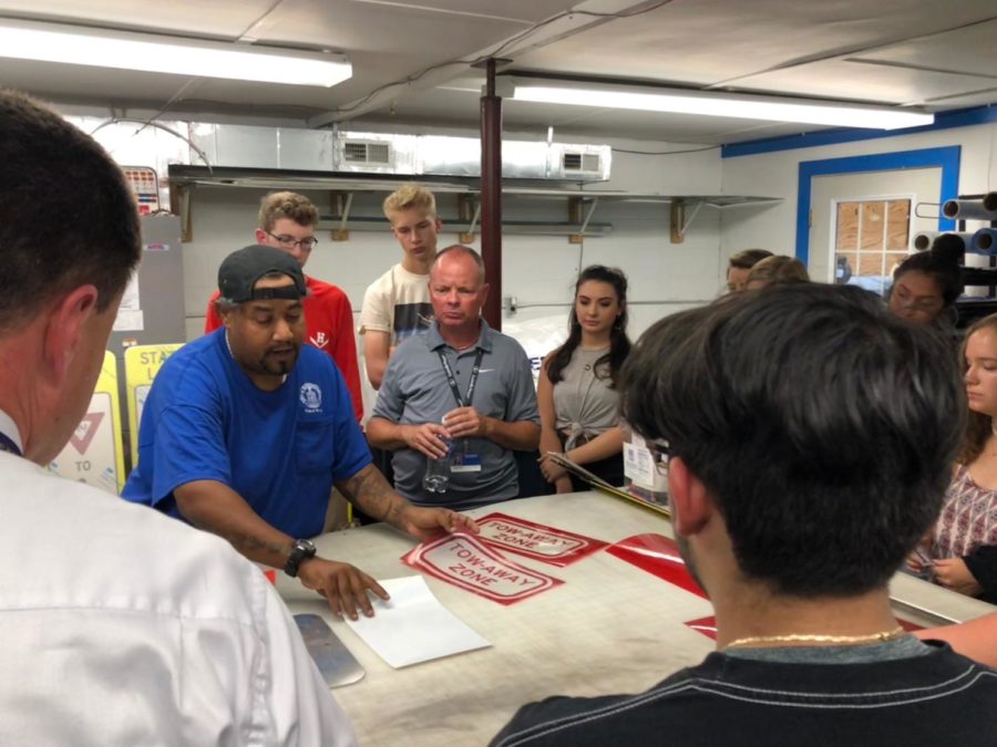 Students in the Honors Government Field Experience class observe the process of making a traffic sign while on their field trip to Public Works. 