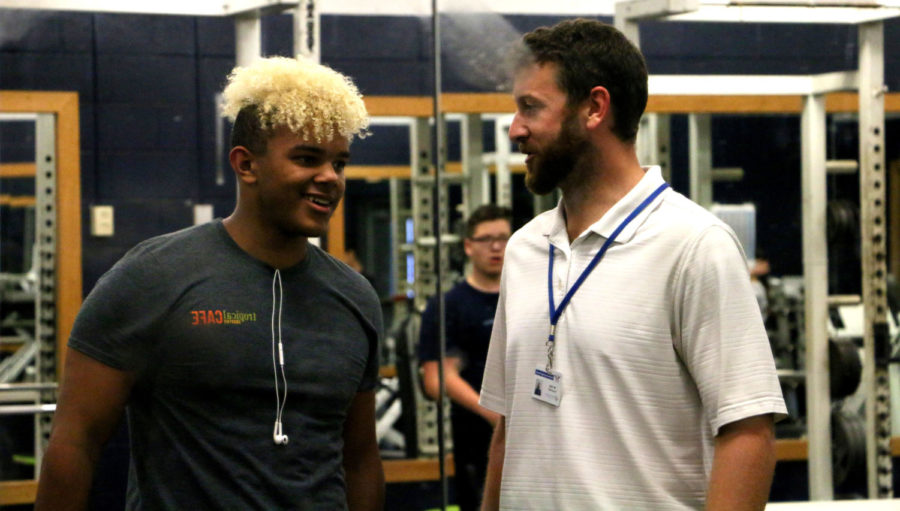 New teacher Roy Kelly speaks to senior Micah Yutzy during weightlifting class. 