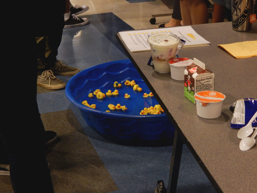 Counselors work the GEAR UP table at lunch. In this activity, students picked a duck and read off the number to the counselors who gave them a question corresponding to the number. If the student answered correctly then they would get the duck they chose.