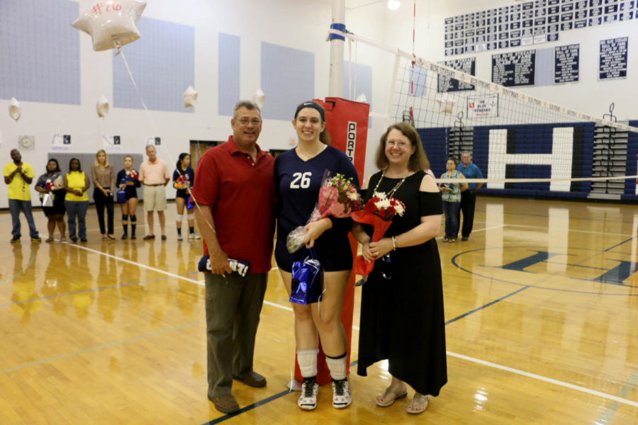 Senior Becky Staton poses with her parents on senior night. 