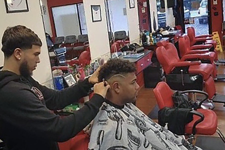 Delgado gives senior Jungle Rodriguez a haircut at Corte Latino, where Delgado currently works.