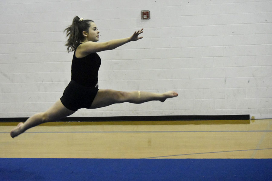 Sophomore Chloe Nicholes leaps during the warm up.