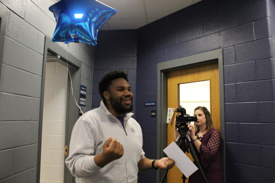 Counselor Korey Lamb receives his grant during a college application session in the library. Harrisonburg Education Foundation awarded Lamb with a letter and balloon in congratulations. 