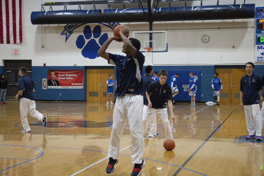 Junior Micheal Kuangu warms up his jump shot before the game.