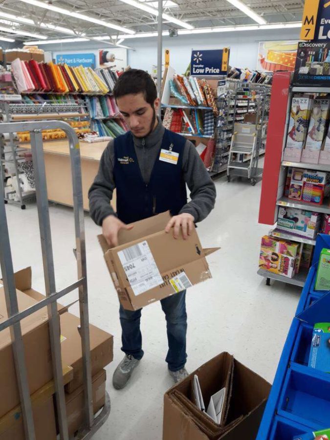 Senior Pana Muhamad breaks down boxes while working the floor at Walmart.