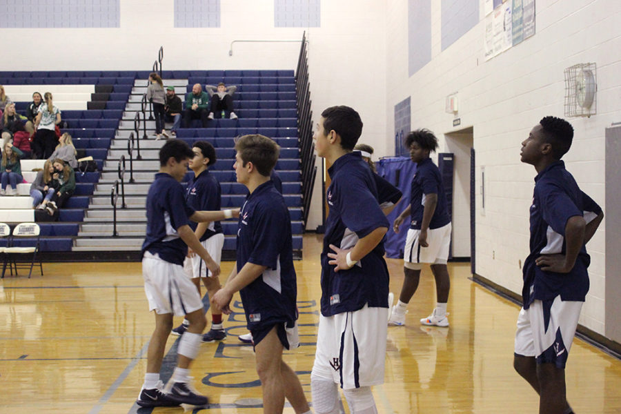 JV Basketball players team look on as their fellow team mates warm up for their match against Broadway.