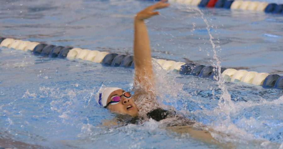 Junior Olivia Arndt swims the final length of her 100 backstroke race. 