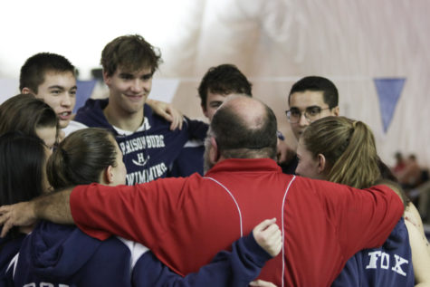 Swim coach Richard Morrell huddles up with the senior swimmers after recognizing them during the meet. 